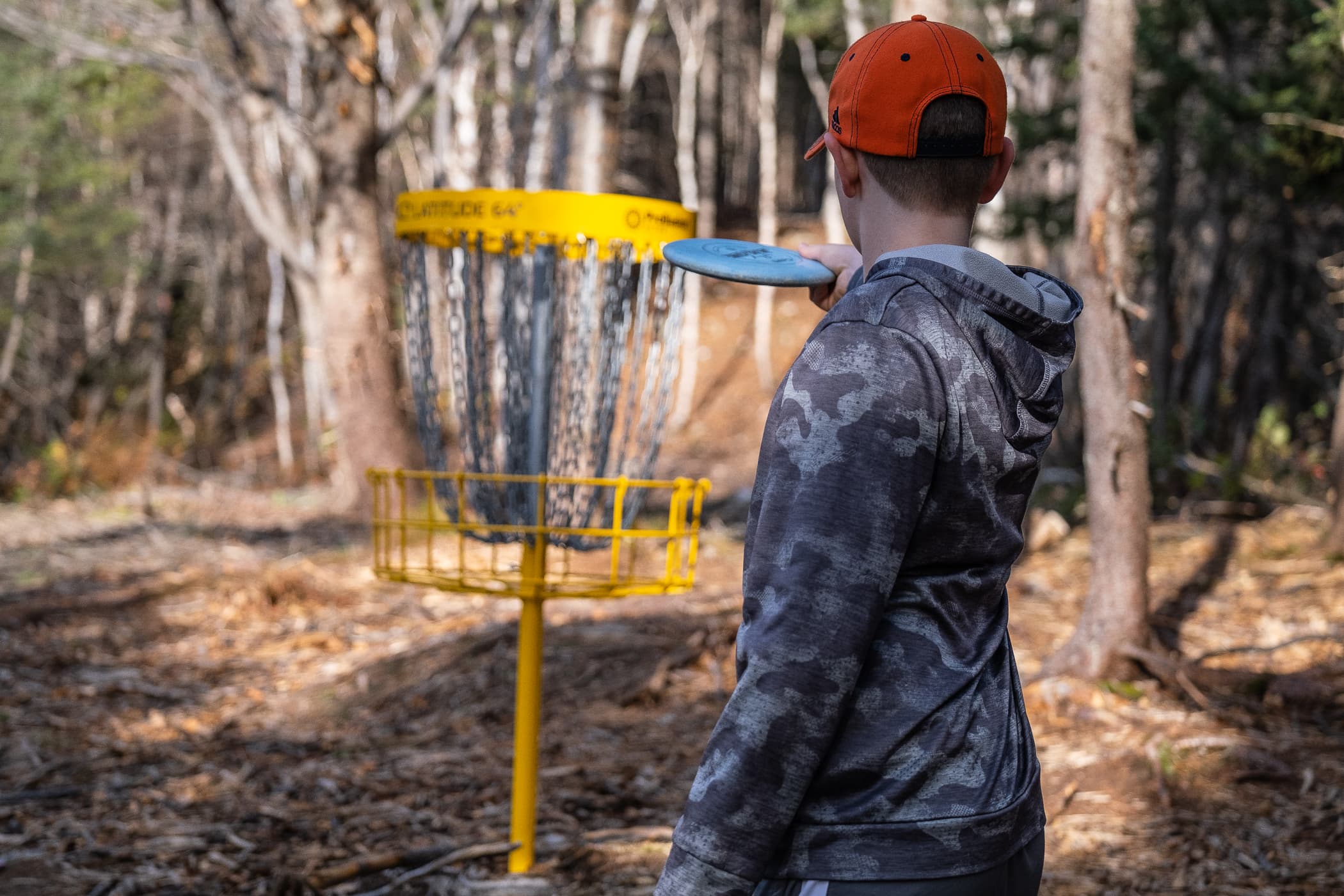 a boy lines up his putt on the CBDG course