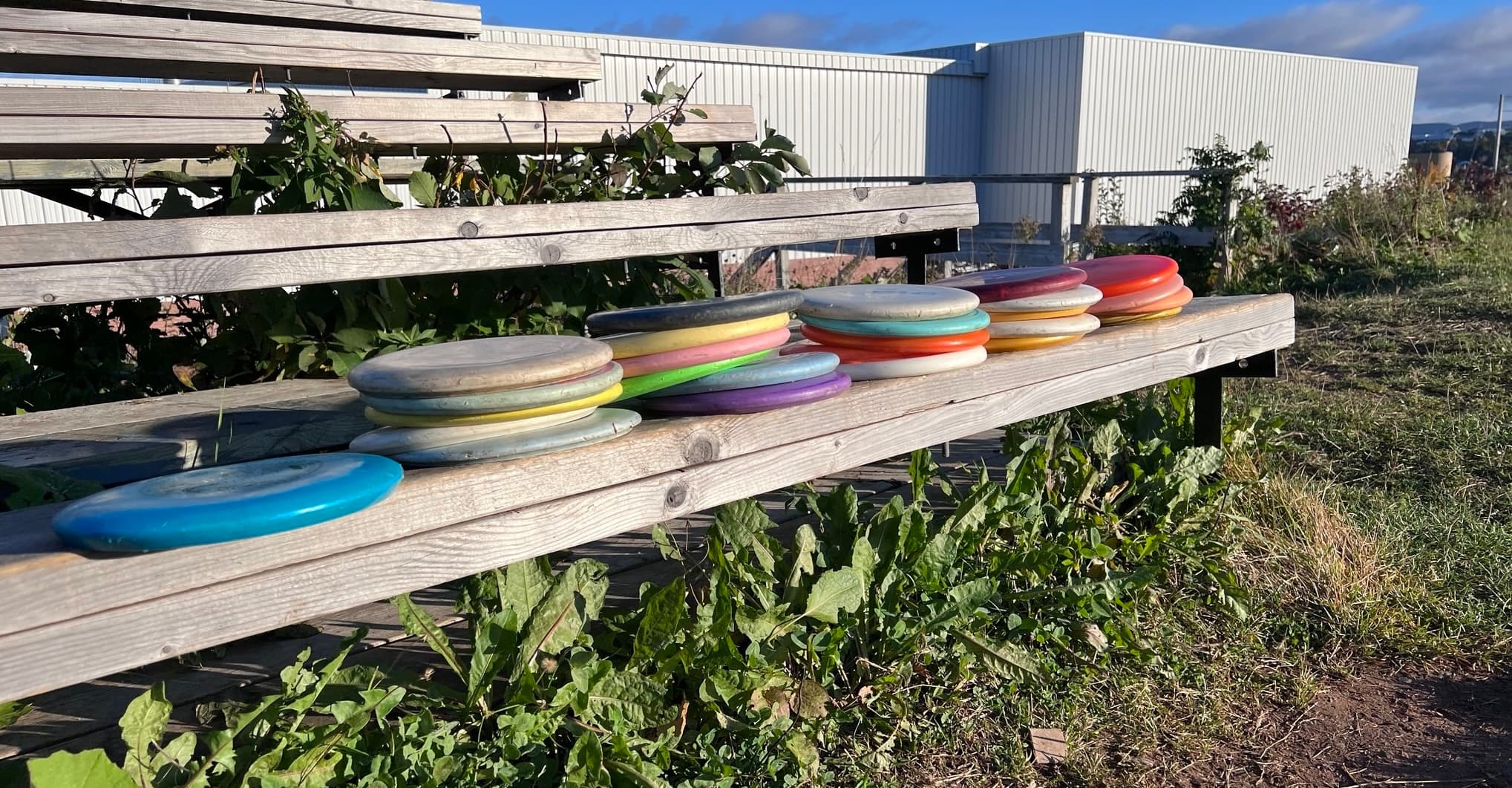 small piles of discs on a soccer field bench